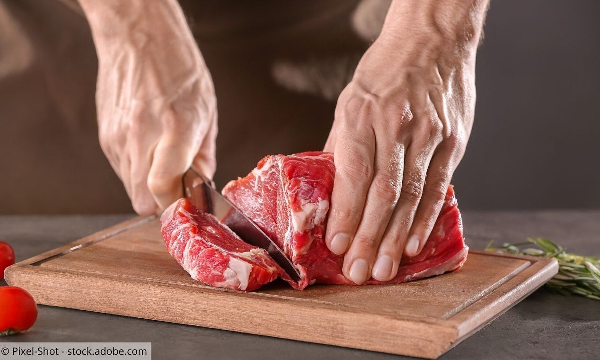 Nahaufnahme von Händen, die Fleisch schneiden